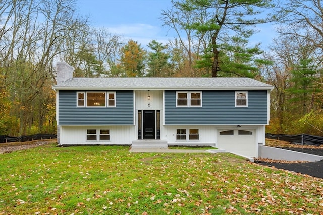 split foyer home featuring a front yard and a garage