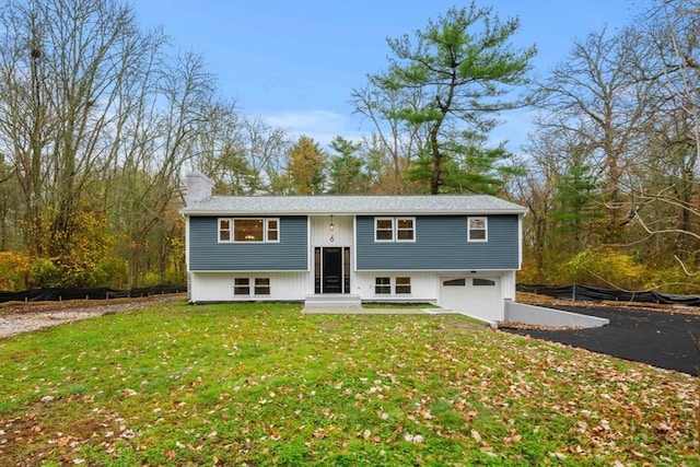 raised ranch with a front yard and a garage