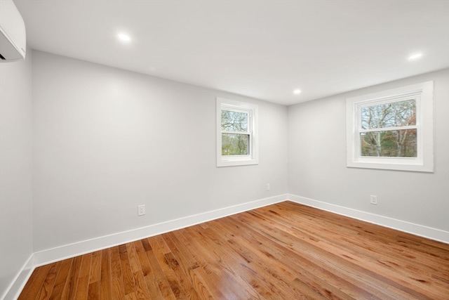 spare room with light hardwood / wood-style flooring and a wall mounted air conditioner