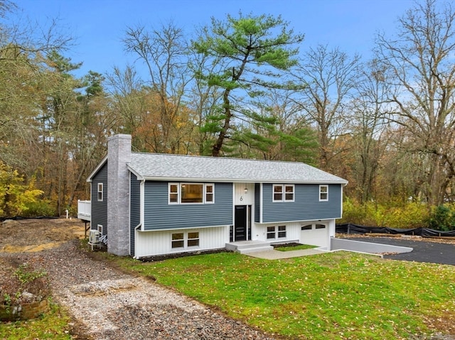 split foyer home featuring a front yard and a garage