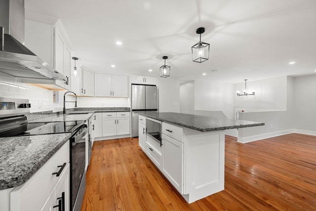 kitchen with sink, stainless steel appliances, a center island, and white cabinets