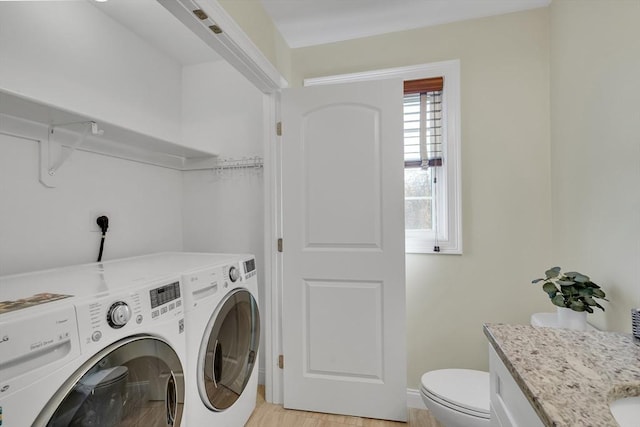 laundry room featuring light hardwood / wood-style floors and washer and dryer