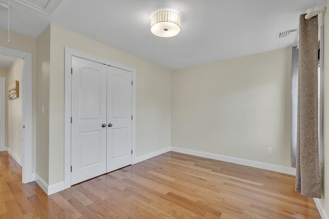 unfurnished bedroom featuring light hardwood / wood-style flooring and a closet