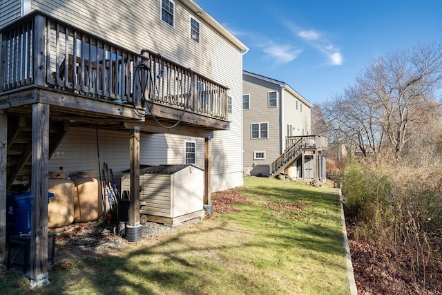 back of property featuring a yard, a deck, and a storage unit