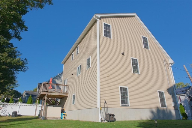 back of house featuring central AC, a lawn, and a deck