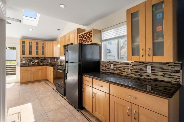 kitchen featuring freestanding refrigerator, light brown cabinetry, light tile patterned flooring, a sink, and backsplash