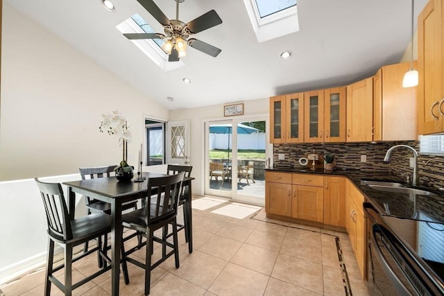 kitchen with a sink, lofted ceiling with skylight, backsplash, and glass insert cabinets