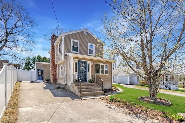 traditional home featuring a front lawn, fence, driveway, and a chimney
