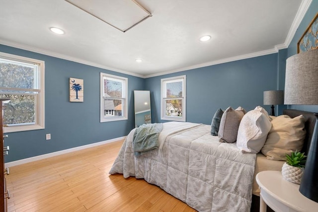 bedroom with baseboards, attic access, wood finished floors, and multiple windows