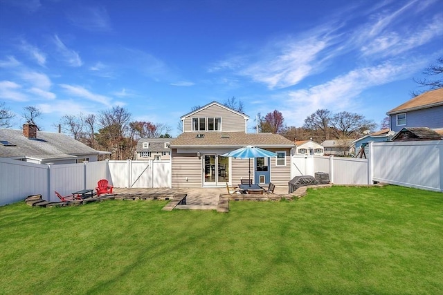 rear view of house featuring a lawn, a patio, and a fenced backyard