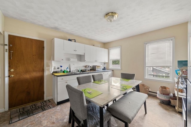 1438 Somerset Ave, Taunton, MA 02780 - dining room featuring a baseboard radiator, a textured ceiling, baseboards, and light stone finish flooring