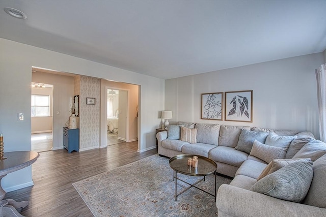 living area with baseboards and dark wood-style flooring