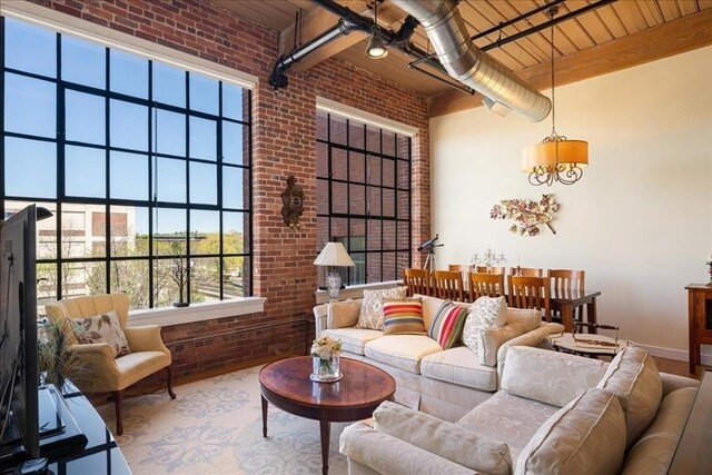 living area with baseboards, wood ceiling, brick wall, and wood finished floors