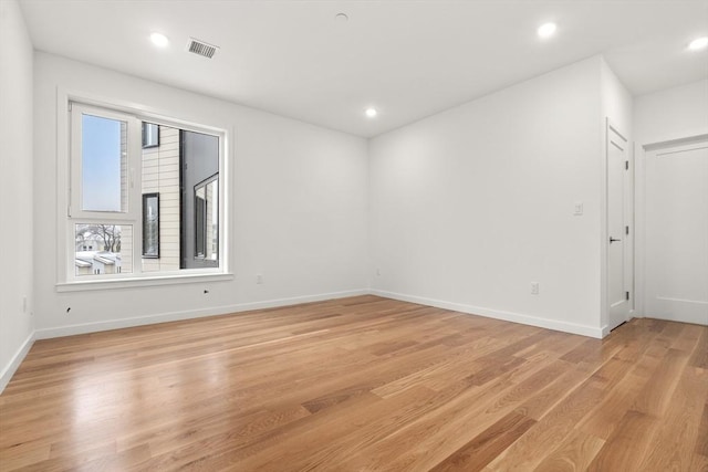 unfurnished room featuring light wood-style floors, baseboards, visible vents, and recessed lighting