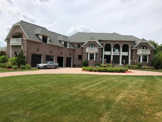 view of front of house with an attached garage, brick siding, driveway, and a front yard