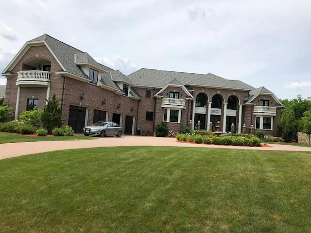 view of front facade with a garage, driveway, brick siding, and a front yard