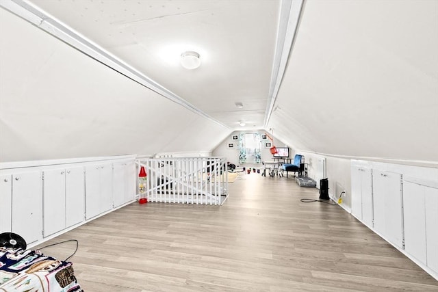 additional living space with vaulted ceiling and light wood-style flooring