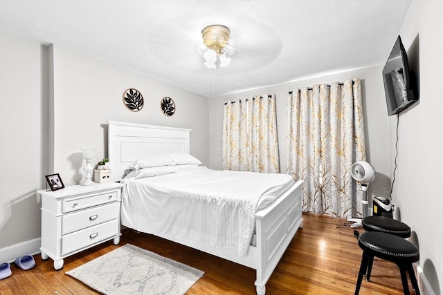 bedroom with baseboards and wood finished floors