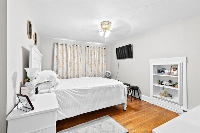 bedroom featuring baseboards and wood finished floors