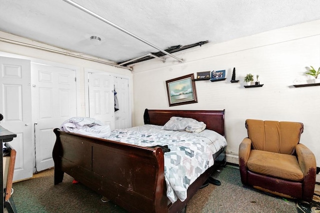 bedroom with dark colored carpet and a baseboard radiator