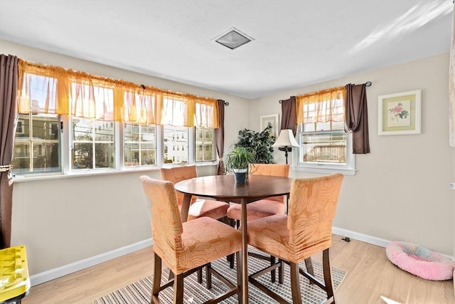 dining space featuring light wood finished floors and baseboards