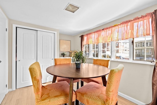 dining area with visible vents, light wood-style flooring, and baseboards