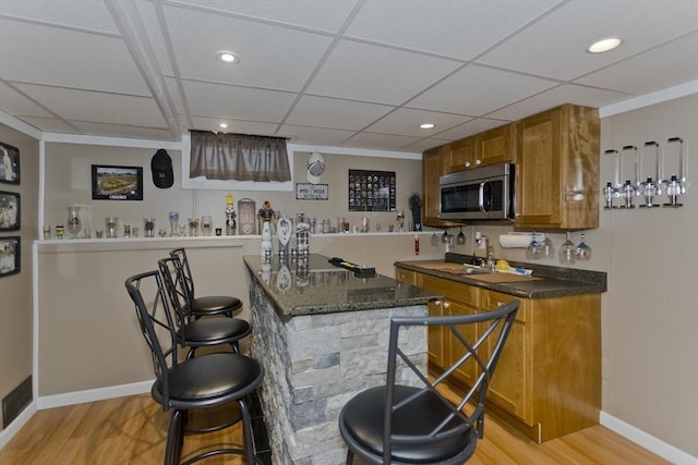 83 Chalmers St, Springfield, MA 01118 - indoor wet bar with stainless steel microwave, light wood-style floors, recessed lighting, baseboards, and a paneled ceiling