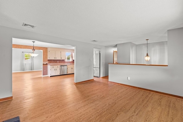 171 Duffy Dr, Taunton, MA 02780 - unfurnished living room featuring baseboards, healthy amount of natural light, light wood-style floors, and a textured ceiling
