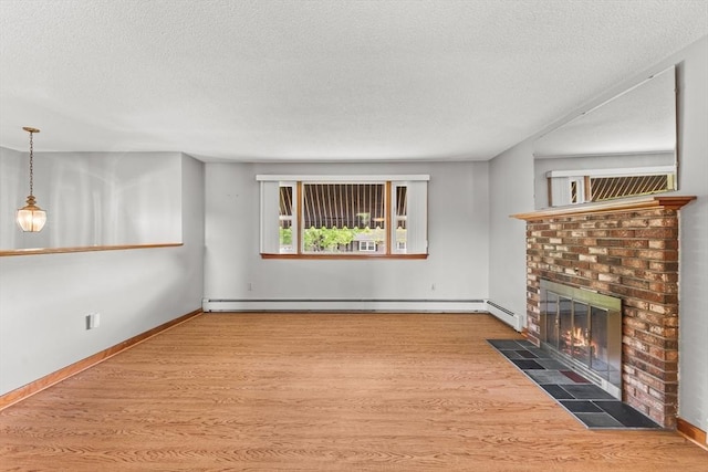 171 Duffy Dr, Taunton, MA 02780 - unfurnished living room featuring a baseboard radiator, wood finished floors, a brick fireplace, a textured ceiling, and baseboards