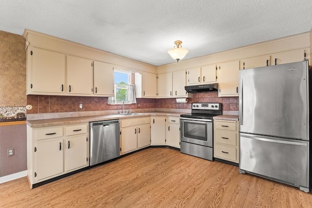 171 Duffy Dr, Taunton, MA 02780 - kitchen featuring appliances with stainless steel finishes, under cabinet range hood, a sink, light wood finished floors, and a textured ceiling