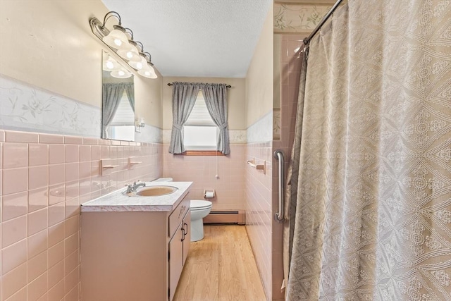 171 Duffy Dr, Taunton, MA 02780 - full bath with a baseboard heating unit, a wainscoted wall, tile walls, vanity, and toilet