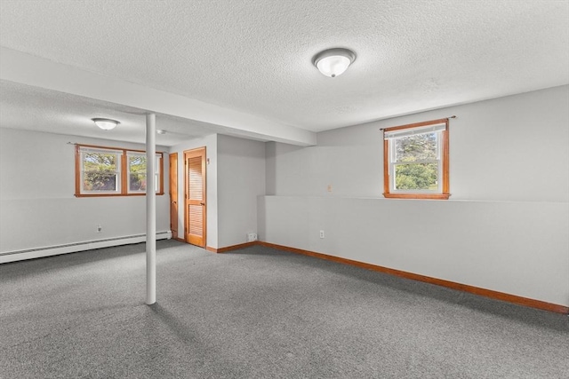 171 Duffy Dr, Taunton, MA 02780 - below grade area featuring a baseboard heating unit, a textured ceiling, carpet flooring, and baseboards