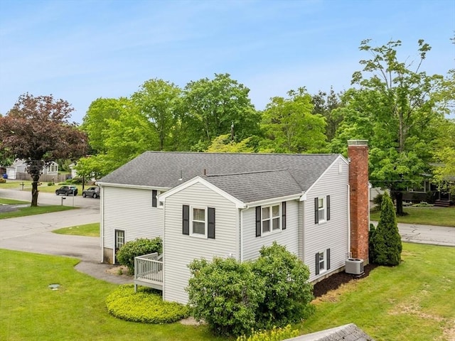 171 Duffy Dr, Taunton, MA 02780 - view of home's exterior with central air condition unit, a yard, a chimney, and roof with shingles