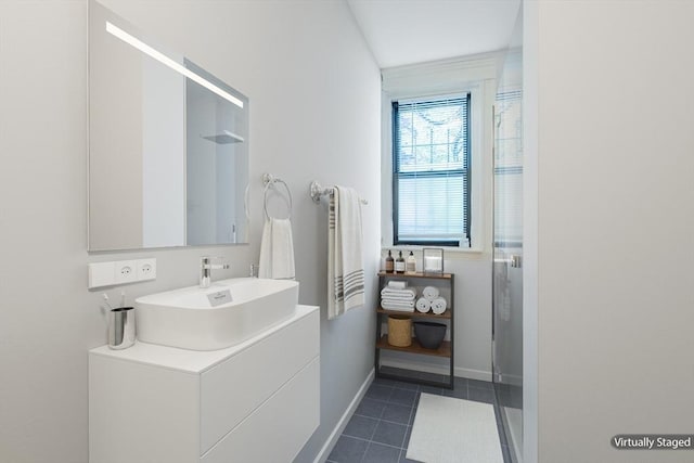 full bathroom with baseboards, vanity, tile patterned floors, and a shower stall