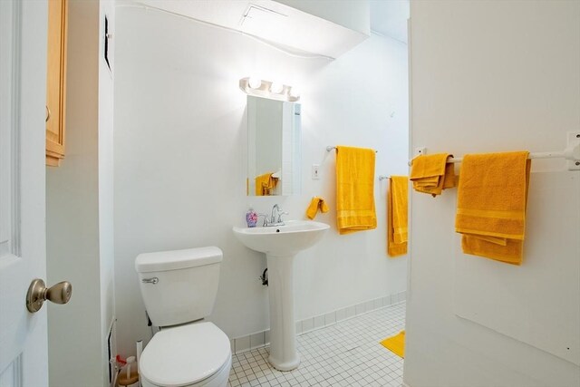 bathroom with tile patterned flooring, toilet, and a sink