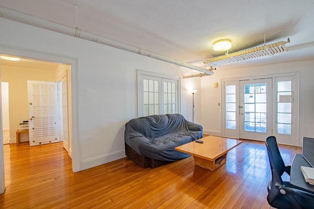 living area with light wood-type flooring and baseboards