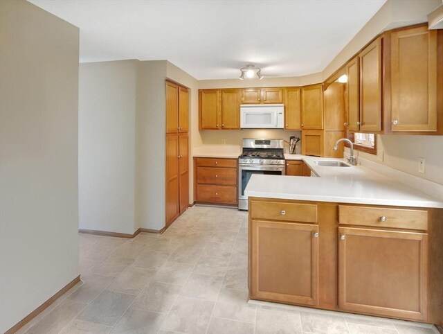18 Sharron Dr Unit 18, Easton, MA 02375 - kitchen with white microwave, stainless steel range with gas stovetop, light countertops, brown cabinetry, and a peninsula