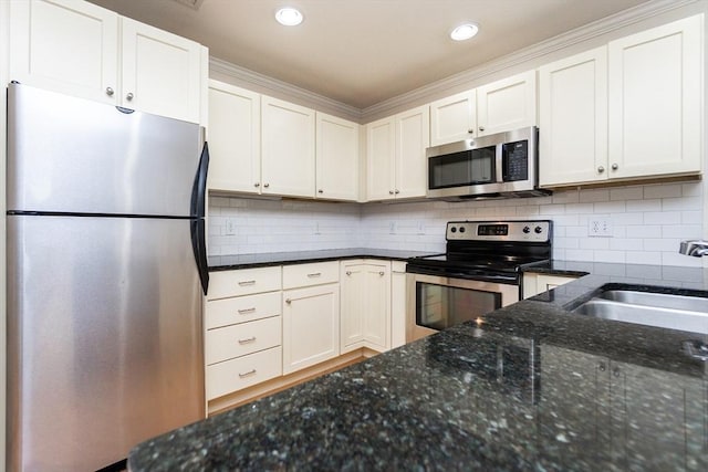 8 Crowninshield Unit 312, Peabody, MA 01960 - kitchen with appliances with stainless steel finishes, a sink, dark stone countertops, decorative backsplash, and recessed lighting