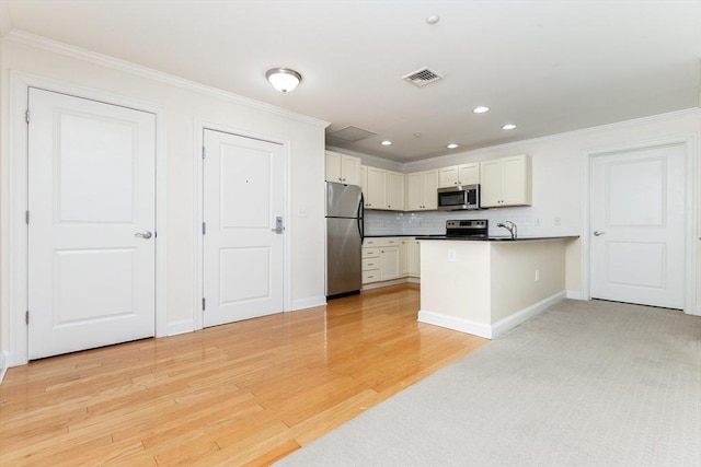 8 Crowninshield Unit 312, Peabody, MA 01960 - kitchen with appliances with stainless steel finishes, a peninsula, crown molding, a sink, and white cabinets