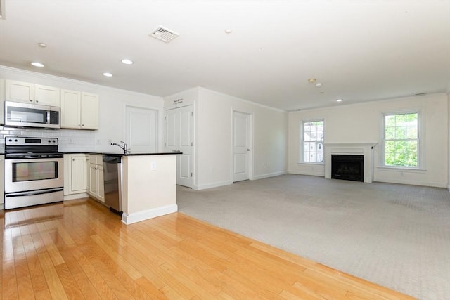 8 Crowninshield Unit 312, Peabody, MA 01960 - kitchen with stainless steel appliances, a peninsula, ornamental molding, baseboards, and decorative backsplash