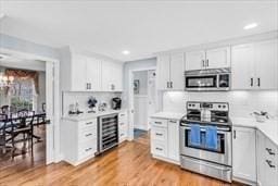 5 Hickory Rd, Southborough, MA 01772 - kitchen with appliances with stainless steel finishes, wine cooler, light countertops, recessed lighting, and white cabinets