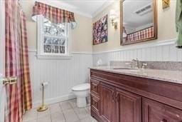 5 Hickory Rd, Southborough, MA 01772 - full bath with toilet, vanity, tile patterned flooring, a wainscoted wall, and crown molding