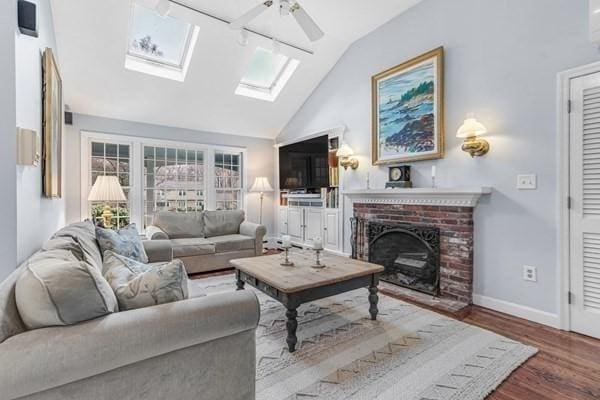 5 Hickory Rd, Southborough, MA 01772 - living area featuring ceiling fan, lofted ceiling, wood finished floors, a fireplace, and a skylight