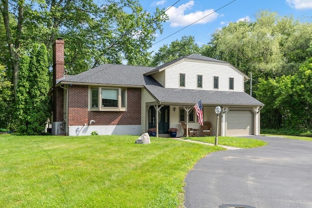18 Mann St, Bellingham, MA 02019 - split level home featuring a chimney, driveway, brick siding, a front lawn, and a shingled roof