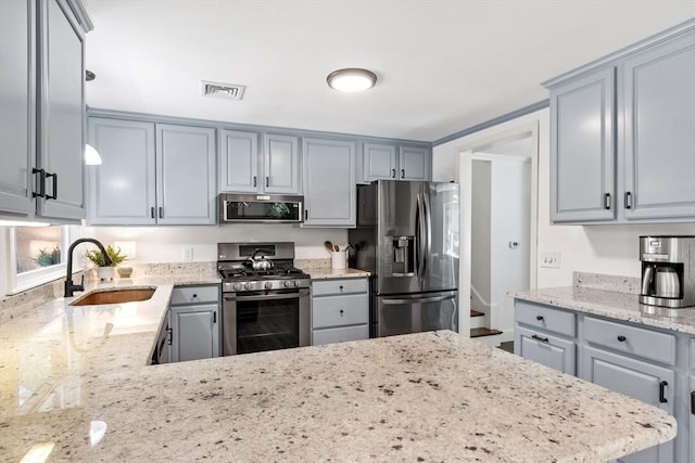 18 Mann St, Bellingham, MA 02019 - kitchen with stainless steel appliances, light stone countertops, gray cabinets, and a peninsula