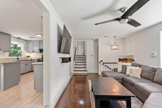 18 Mann St, Bellingham, MA 02019 - living area featuring light wood finished floors, ceiling fan, crown molding, and stairway