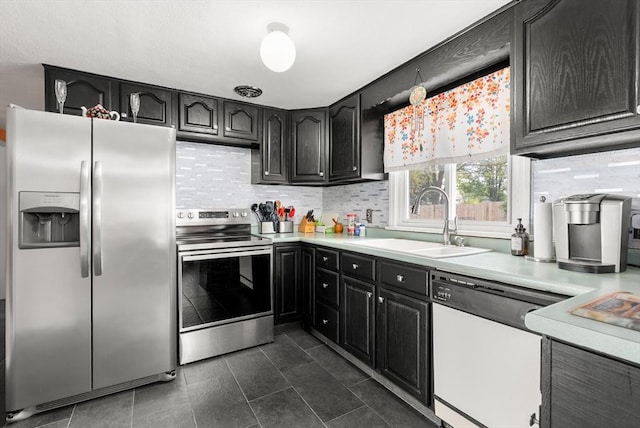 kitchen with stainless steel appliances, a sink, backsplash, and light countertops