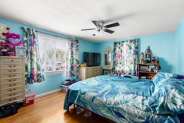 bedroom featuring wood finished floors, baseboards, and ceiling fan