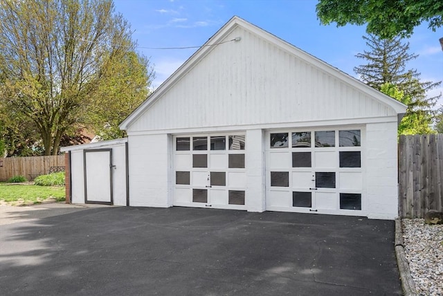 detached garage featuring fence