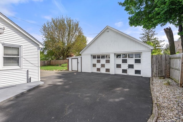 detached garage featuring fence